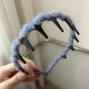 Detail of blue knitted wool headband featuring non-slip black teeth for a secure grip