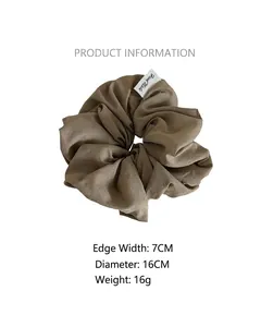 Détail du chouchou café de 16cm avec une étiquette tissée blanche Hand Made
