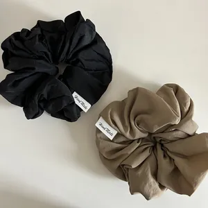 Détail de chouchous à haute élasticité noirs et kaki avec étiquettes tissées Hand Made