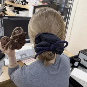 Puffy fabric scrunchies with bow tie detail in brown and navy blue colors