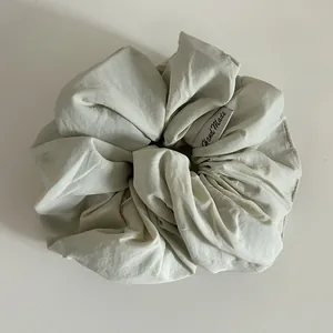 Détail de la texture du tissu en coton et de l'étiquette Hand Made du chouchou