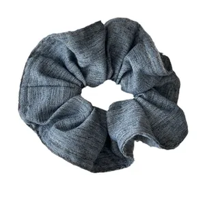 Chouchou en denim bleu foncé avec double couture fine sur fond blanc