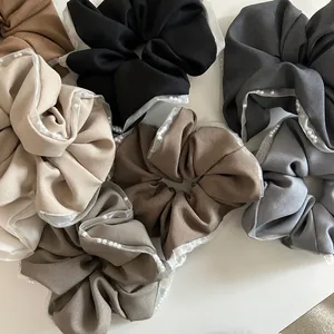 Detailed view of layered fabric scrunchies with white lace edges and pearl accents