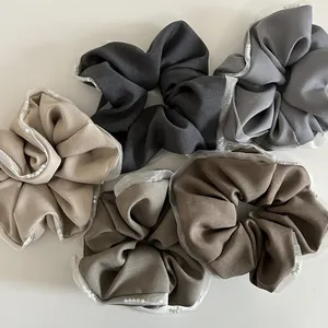 Detail of five earth-toned mesh hair scrunchies with white pearls and organza edges