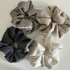 Detail view of four textured mesh scrunchies with elegant faux pearl embellishments