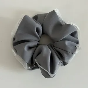 Detail of grey mesh lace scrunchie with soft fabric texture and delicate white pearls