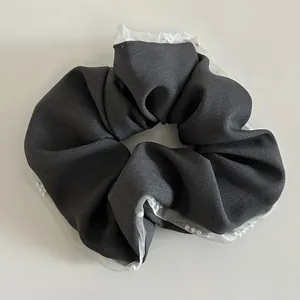 Detail of grey fabric scrunchie with organza lace edges and small pearl embellishments