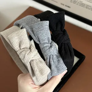 Dettaglio di fasce per capelli in maglia con fiocco in beige, grigio e nero