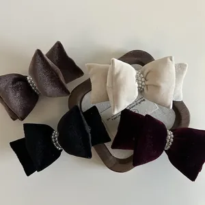 Nahaufnahme von Samt-Haarspangen in vier Farben mit eleganten Details aus Perlenimitaten