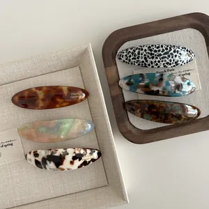 Close-up of tortoise shell and marble acetate hair clips with metal spring mechanism