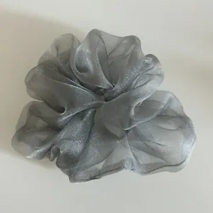 Detailed view of silver organza scrunchie texture with semi-transparent pleated layers