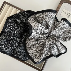 Floral oversized scrunchies set with black satin trim on a vintage display tray
