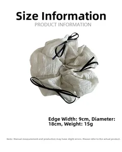 Detail view of white ruffled scrunchie with black ribbon showing 18cm diameter and 9cm width