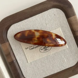 Macro detail of tortoiseshell acetate hair clip with golden France Handmade stamp