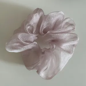 Macro detail of lavender organza scrunchie featuring elegant pearlescent mesh texture