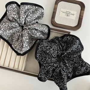 Floral oversized scrunchie set with satin edges on a cream jewelry display tray