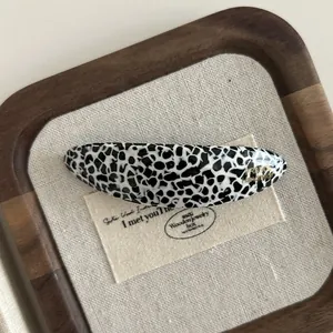 Close-up of Dalmatian print acetate hair clip featuring a gold France Handmade logo