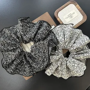 Detail of floral chiffon scrunchies showing fabric texture and black edge stitching
