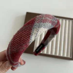 Dettaglio del cerchietto spesso in lana scozzese rossa con etichetta interna fatta a mano