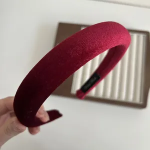 Detail view of wine red velvet padded headband showing thick sponge and handmade label