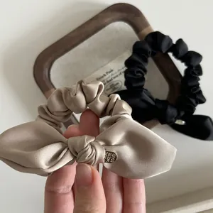 Elegant champagne and black satin bow scrunchies with heart-shaped metal charms
