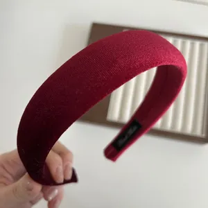 Close-up of burgundy velvet headband featuring a soft texture and Hand Made interior label