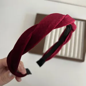 Detailed close-up of wine red velvet headband showing soft texture and twisted design