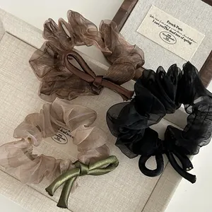 Three-pack organza and satin bow scrunchies in brown, beige, and black colors