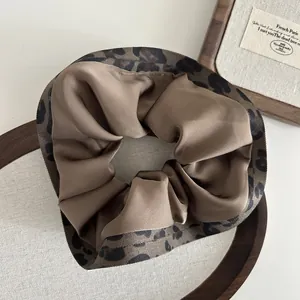 Close-up of leopard print and coffee satin fabric patchwork on large scrunchie