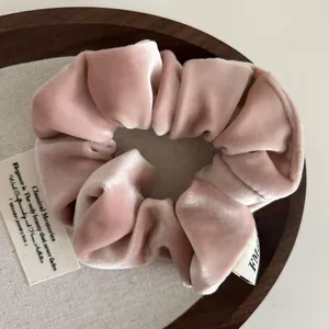 Close-up of dusty pink velvet scrunchie showing soft texture and premium glossy finish