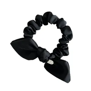 Elegant black satin bow scrunchie with silver Made With Love metal charm detail