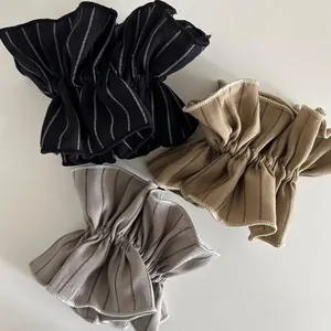 Detail of striped scrunchies in black, khaki, and gray with ruffled pleated texture