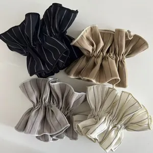Set of four striped ruffle scrunchies in black, khaki, grey, and cream colors