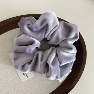Elegant lavender velvet scrunchie for women on a rustic wooden tray decoration