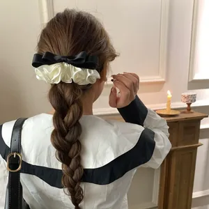 Chouchou élégant en satin crème avec un nœud en soie noire pour coiffure ballet