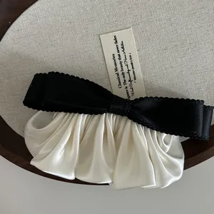 Barrette nœud en satin crème élégante avec bordure noire ondulée style ballet