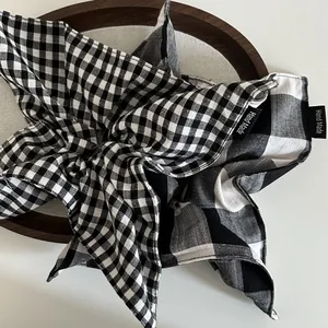 Retro black and white checkered fabric scrunchies with handcrafted labels on a wooden tray