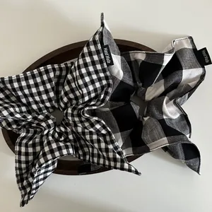 Detail of two black and white checkered hair scrunchies with Hand Made woven labels