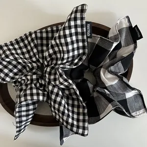 Detail of plaid fabric scrunchie with Hand Made label on a wooden tray