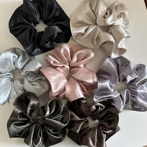 Sette elastici per capelli in raso colorato con lucentezza setosa su sfondo bianco