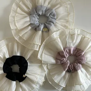 Set of three oversized double-layer lace scrunchies with golden labels in grey pink and black