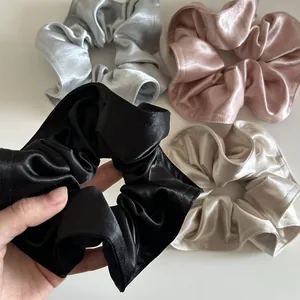 Set di grandi elastici scrunchie in raso nero, argento, rosa e champagne su bianco
