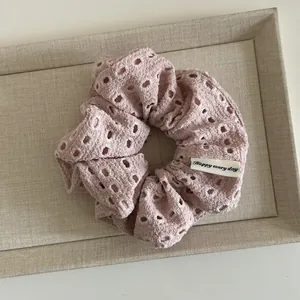 Floral cutout pink scrunchie with Happy Every Day label on beige display tray