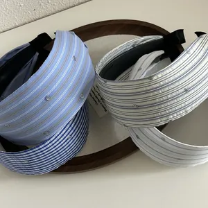 Close-up of wide striped headbands with subtle sequins in light blue and navy tones