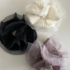 Three-piece set of oversized pleated organza scrunchies in cream, black, and dusty pink