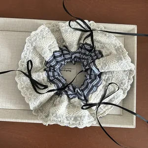 Elegant blue striped scrunchie with cream lace trim and long black ribbon bows