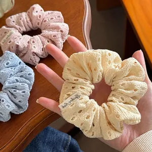 Pastel floral hollow-out embroidery scrunchies in pink, blue, and yellow fabric