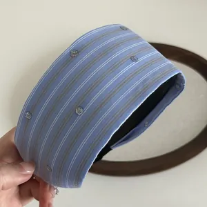 Close-up of wide blue striped headband with silver sequins and black non-slip inner lining