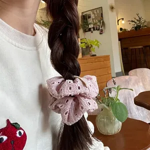 Pink floral hollow embroidery scrunchie hair tie on brown braided hair lifestyle shot