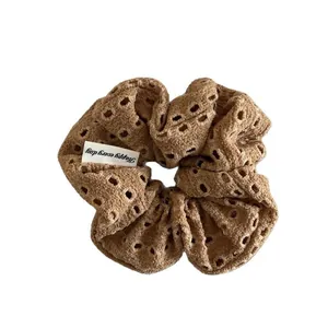 Brown crochet floral hair scrunchie with hollow texture and Happy Every Day tag
